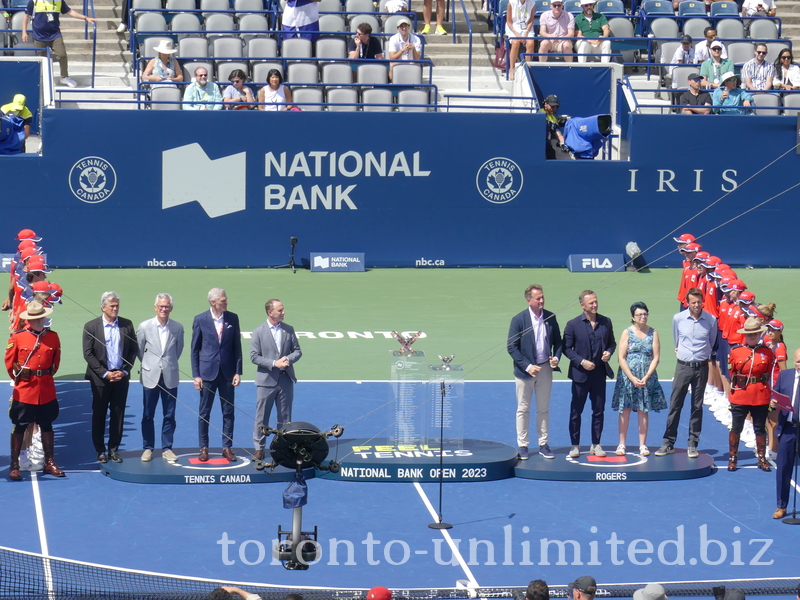 Runners-up and Champions Trophy on display between members of the Organizing Committee. 