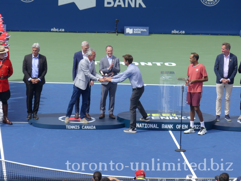 Daniel Nestor hands a Trophy bearing his name to Michael Denham for the presentation to the Winners.