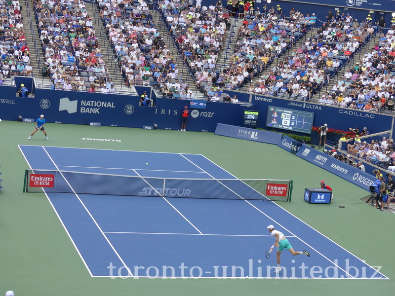 Jannik Sinner serving to Alex De Minaur on Centre Court