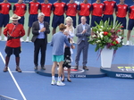 Jannik Sinner is accepting the Championship Trophy from Lucie Blanchet of the National Bank