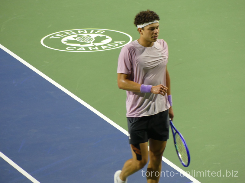 Close-up of Ben Shelton with a sweaty shirt walking on Centre Court during the NBO 2025 Championship match. 