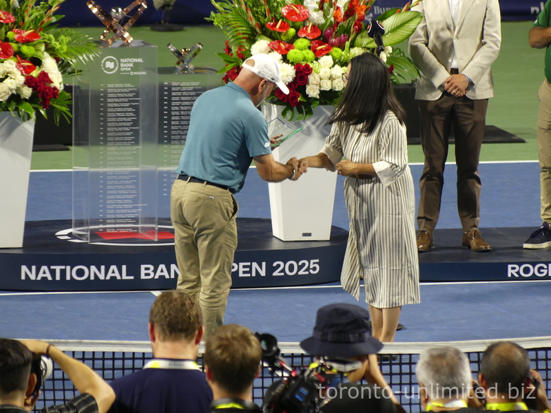 Linda is presenting Chair Umpire Fergus Murphy with a commemorative plaque