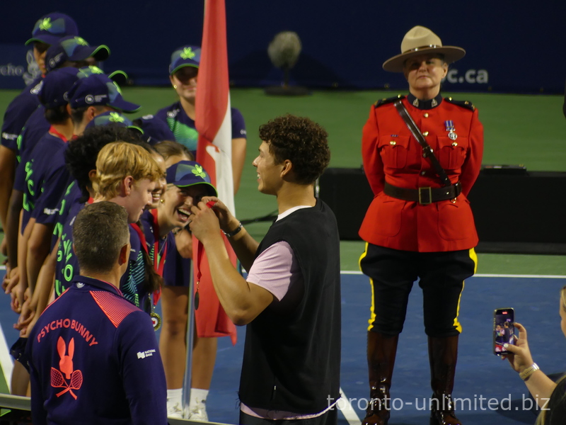 A closeup of the ball crew members getting the medals from the Champion Ben Shelton. August 7, 2025