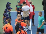 Lloyd Glasspool is presenting the ball crew with commemorative medals.