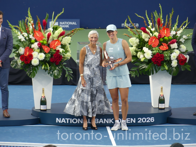 Iga Swiatek holding her Trophy and posing with Lucie Blanchet