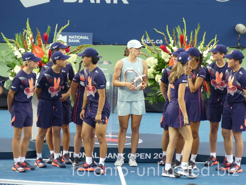 Champion Iga Swiatek with her Trophy in the middle of ball kids crew