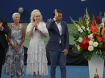 A guest member of the official party with raised hand