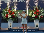 Happy Iga Swiatek is kissing her Trophy with the fireworks behind