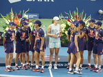 Champion Iga Swiatek with her Trophy in the middle of ball kids crew