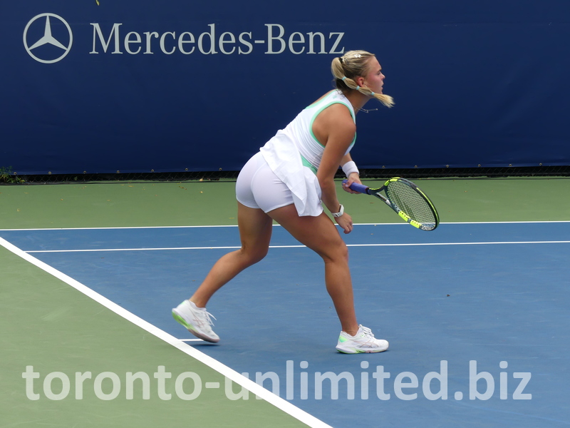 Sara Bejlek's posture shows her finishing her serve.