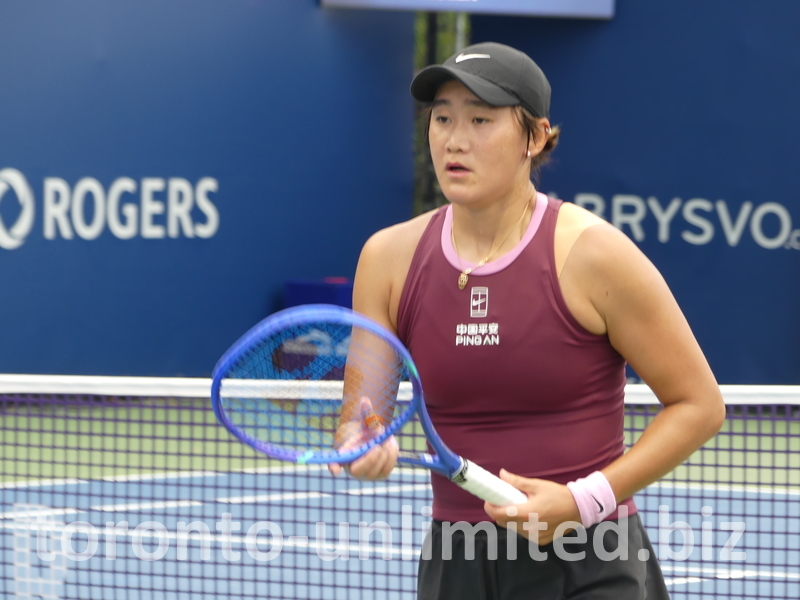 Close-up photo of Xiyu WANG in a tennis match on a tennis court.