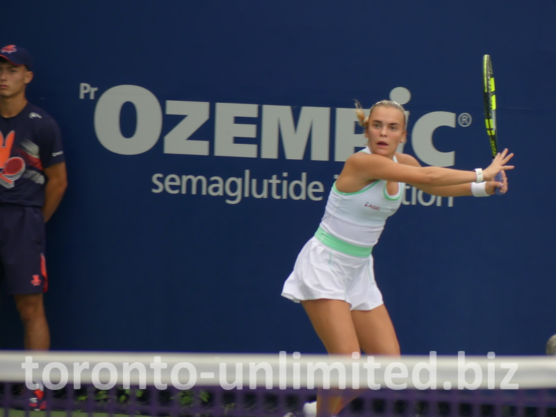 Sara Bejlek is watching the tennis ball to strike it. 