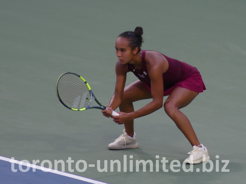 Crouching, Leylah Fernandez expects to return the serve.