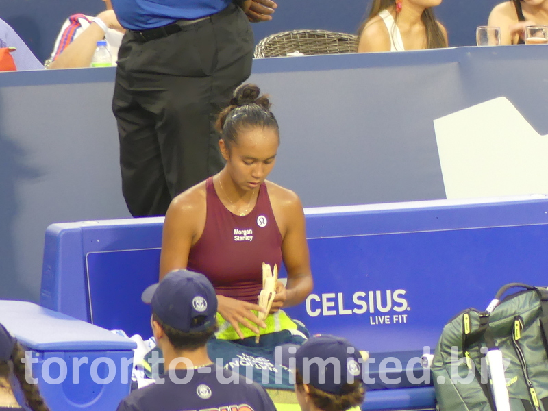 Leylah Fernandez snacks on a banana during the break.
