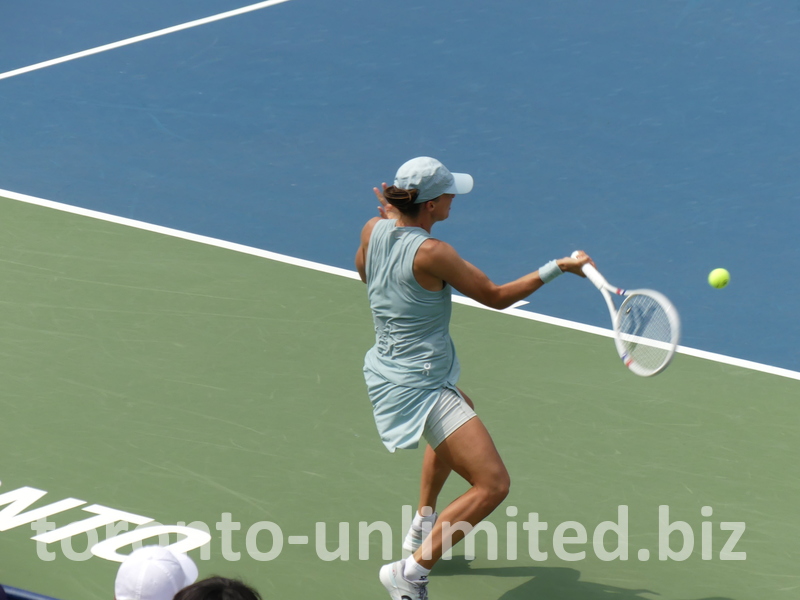 Iga Swiatek is about to hit the forehand shot behind the baseline.