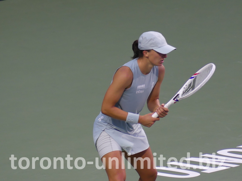 Iga Swiatek holds a strong posture with her racquet.