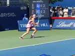 Running Mirra Andreeva chasing the ball behind the baseline.