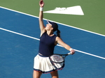Kayla Day is tossing the ball high to serve.
