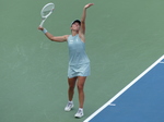 Iga Swiatek is in the serving posture with a high-toss ball.