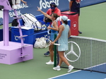 Iga Swiatek has won the match and walks with Marta Kostyuk to shake hands with the umpire.