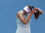 A close-up of Elena Rybakina while she fixes her hairdo on the Court during the changeover.