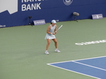 Observing the play, Iga Swiatek stands behind the baseline.