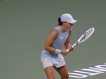 Iga Swiatek holds a strong posture with her racquet.