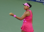Naomi Osaka, with well-manicured hands, holds the tennis ball ready to serve.
