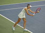 Elena Rybakina is in a serve-preparation posture.