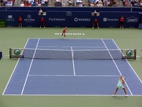 Elena Dementieva serving in far court against Maria Sharapova in front.
