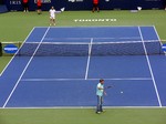 Spectator serving against Andre Agassi on the court