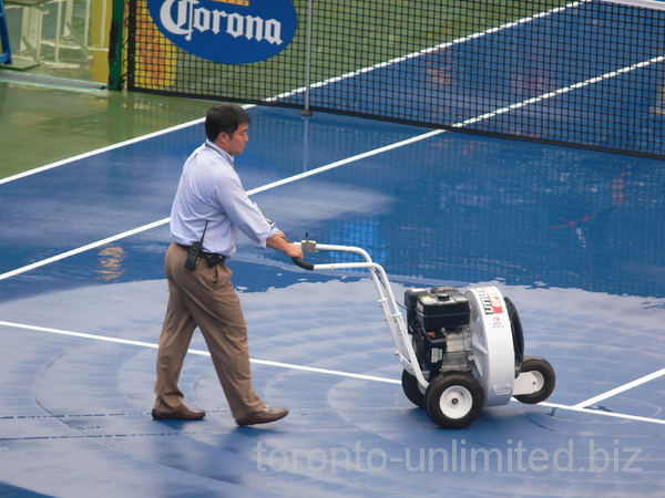 Tonny Cho, referee, is helping to dry up Central Court. August 11, 2012 Rogers Cup.  