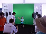 Younge boy is having fun with oversized tennis racquet and receive a photograph to take home.