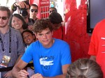 Milos Raonic signing autographs to his fans. 