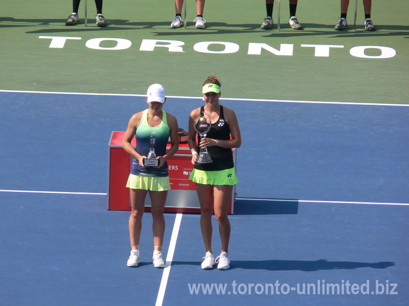 Champion Belinda Bencic and runner-up Simona Halep on Centre Court with a prominent sign promoting Toronto, 16 August 2015 Rogers Cup.