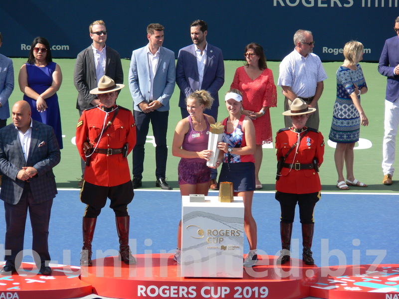 Doubles Champions Barbora Krejcikova and Katerina Siniakova are displaying their Trophy with RCMP Honor Guard on each side. August 11, 2019 Rogers Cup Toronto
