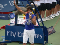 Rafael Nadal walking on the court with his Championship Trophy